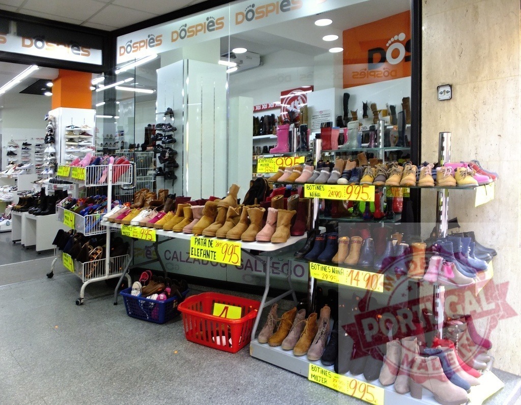 DosPies shoe store displaying boots for sale | DosPies shoe store displaying many boots and shoes with price tags outside - Realized with Pictrs.com