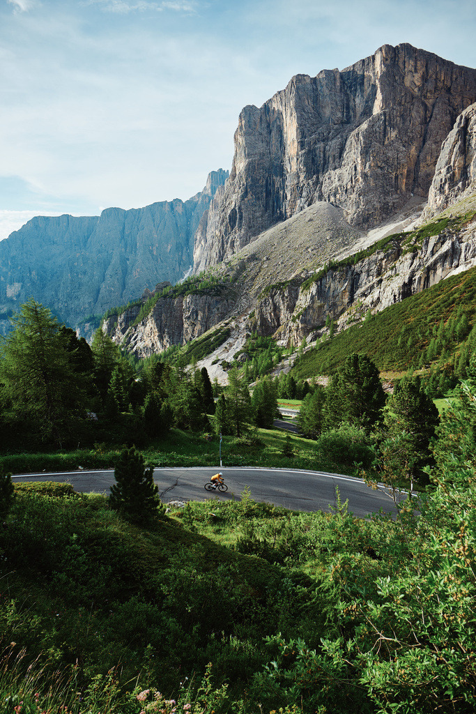 CS-260621-1710-1 | Kleine Spuren in den Dolomiten – Eine einzelne Kehre, ein Rennradfahrer und die gewaltigen Felswände der Sellagruppe. Manchmal genügt ein kleiner Maßstab, um die Größe einer Landschaft sichtbar zu machen.