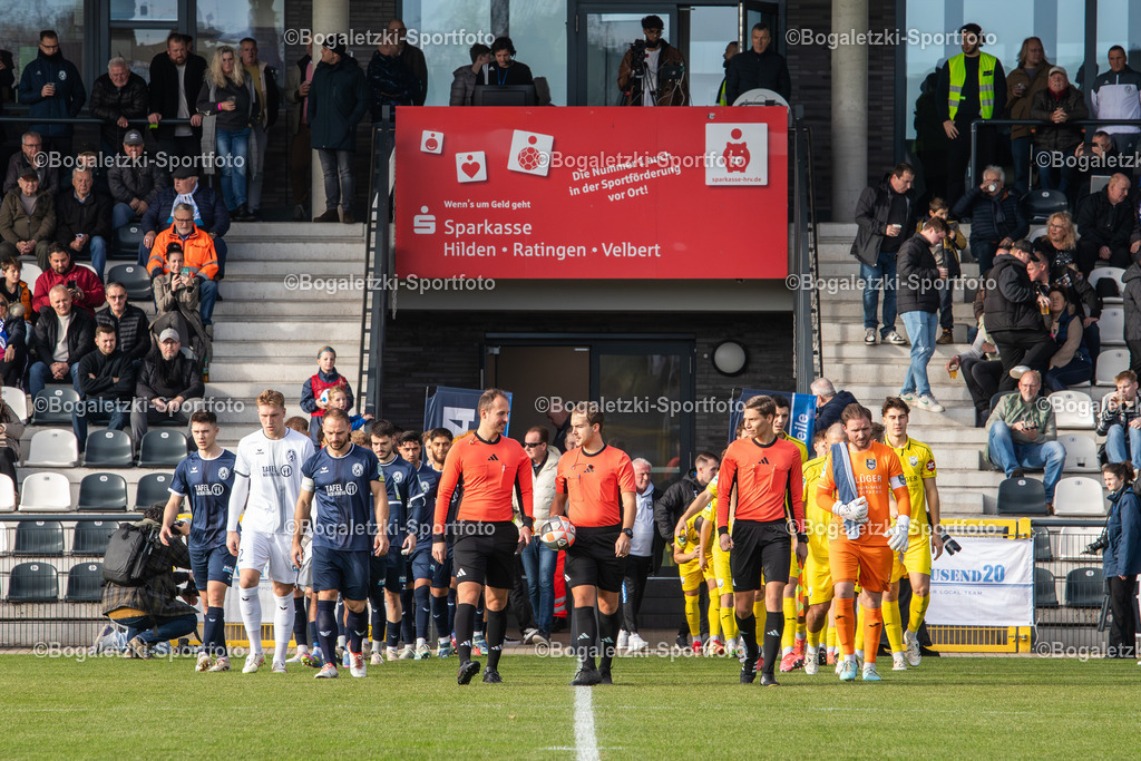 Einlauf | 08.11.2025, Fußball, Regionalliga West, SSVg Velbert - SC Wiedenbrück: Einlauf der Teams, Links Velbert (Blau) und Rechts Wiedenbrück (Gelb) - Realisiert mit Pictrs.com