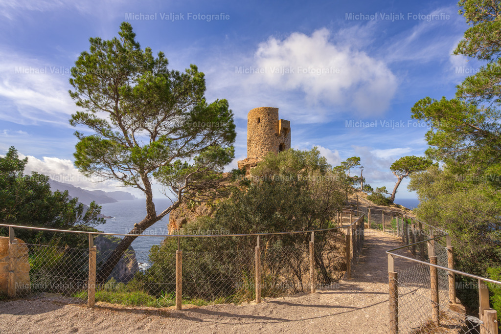 Torre del Verger auf Mallorca | Der Torre del Verger erhebt sich über einem der markantesten Küstenabschnitte der Serra de Tramuntana und verbindet historische Küstenarchitektur mit der offenen Weite des Mittelmeers. Der schlanke Rundturm steht in exponierter Lage über der steil abfallenden Felsküste, wodurch seine frühere strategische Funktion unmittelbar spürbar wird. - Realisiert mit Pictrs.com