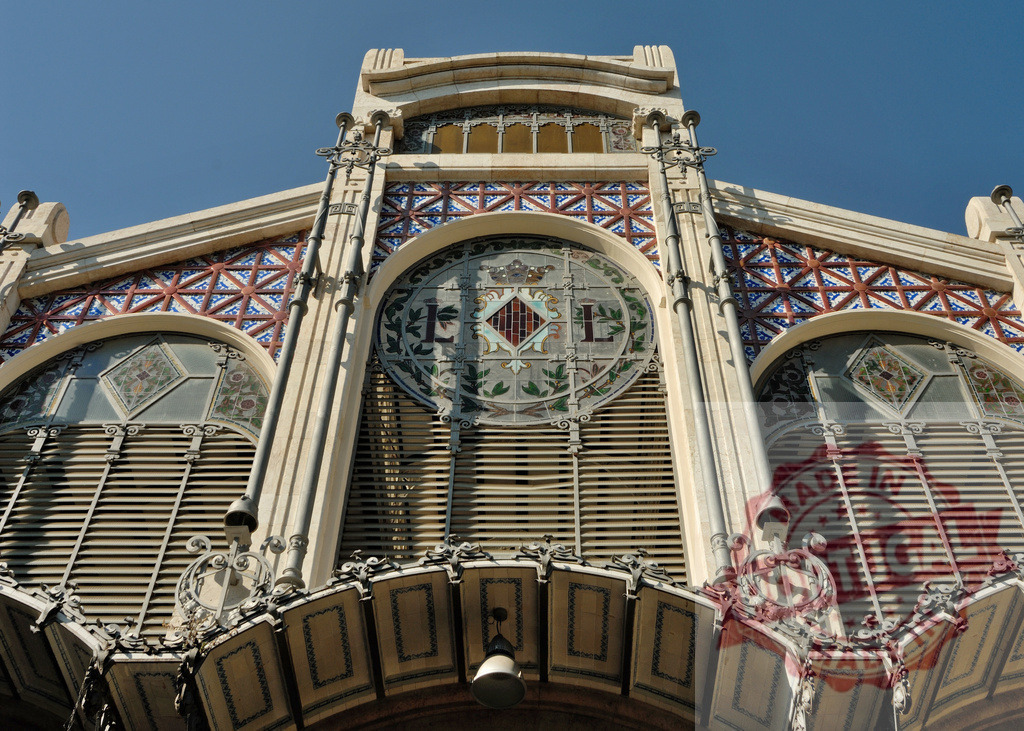 Colón Market facade with colorful Valencian tiles and stained glass windows showing the LL letters | Colón Market facade with colorful Valencian tiles and stained glass windows showing the LL letters, in Valencia, Spain - Realisiert mit Pictrs.com