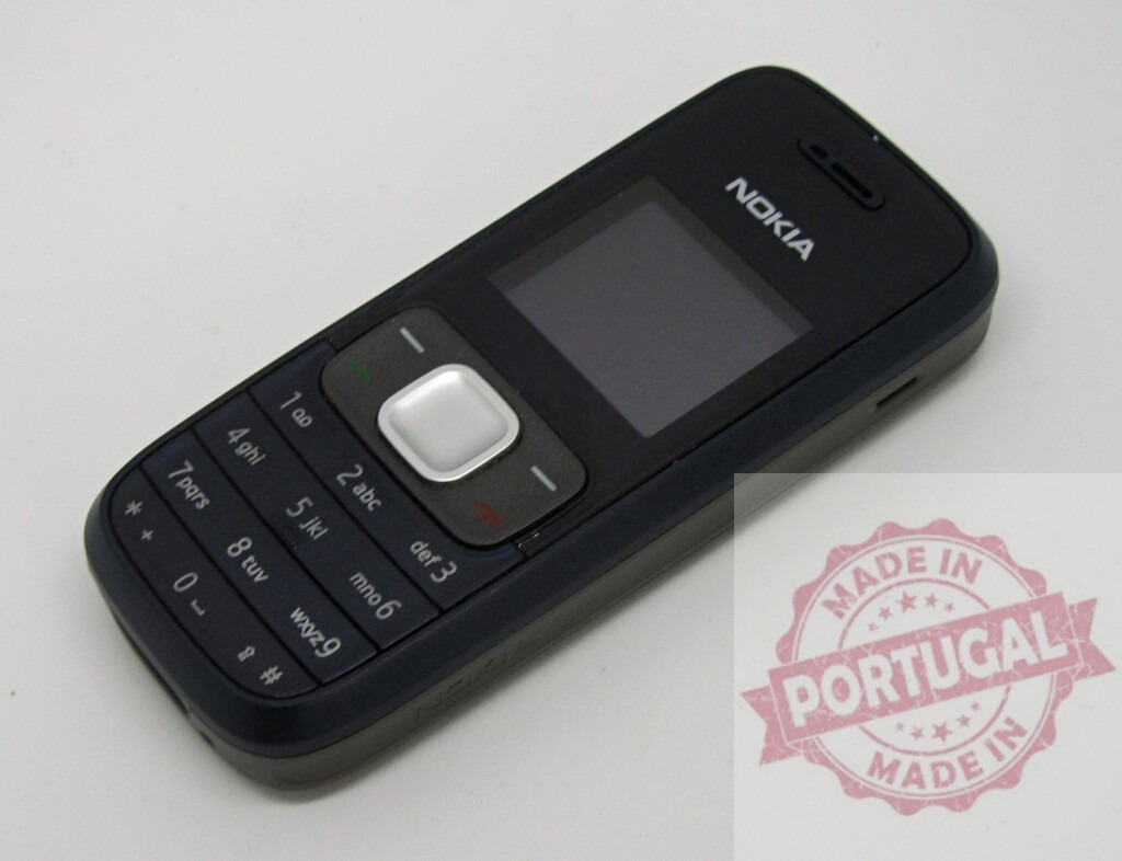 Nokia mobile phone showing keypad and screen lying on white surface | Classic Nokia cell phone resting on a white background, showcasing its keypad and display - Realized with Pictrs.com