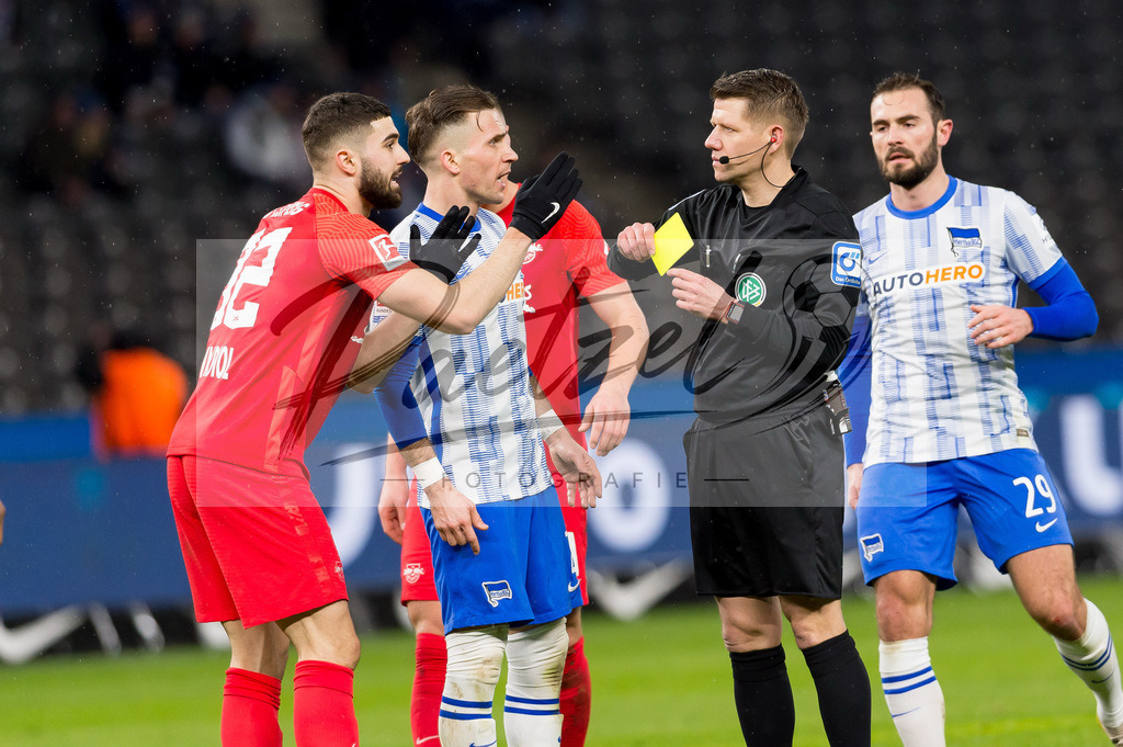 BSCRBL20220220_181 | Fussball, Herren: Schiedsrichter Patrick Ittrich zeigt Josko Gvardiol (RB Leipzig) die gelbe Karte bei dem Spiel der 1. Bundesliga zwischen Hertha BSC und RB Leipzig im Olypiastadion am 20.02.2022 in Berlin, Deutschland.DFB / DFL REGULATIONS PROHIBIT ANY USE OF PHOTOGRAPHS AS IMAGE SEQUENCES AND/OR QUASI-VIDEO. - Realisiert mit Pictrs.com