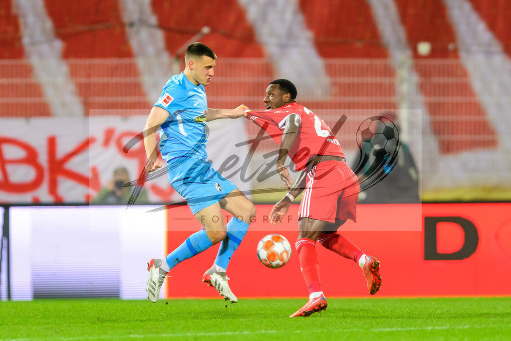 FCUFRE20211215_038 | Fussball, Herren: Maximilian Eggestein (SC Freiburg) und Sheraldo Becker (1. FC Union Berlin) im Zweikampf bei dem Spiel der 1. Bundesliga zwischen 1. FC Union Berlin und SC Freiburg im Stadion An der Alten Foersterei am 15.12.2021 in Berlin, Deutschland.DFB / DFL REGULATIONS PROHIBIT ANY USE OF PHOTOGRAPHS AS IMAGE SEQUENCES AND/OR QUASI-VIDEO. - Realisiert mit Pictrs.com