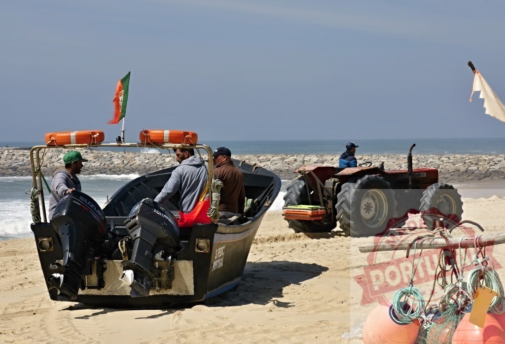 Fishermen preparing boat on Portugal beach with tractor | Fishermen preparing a traditional fishing boat and gear on a sandy beach with a tractor - Realisiert mit Pictrs.com