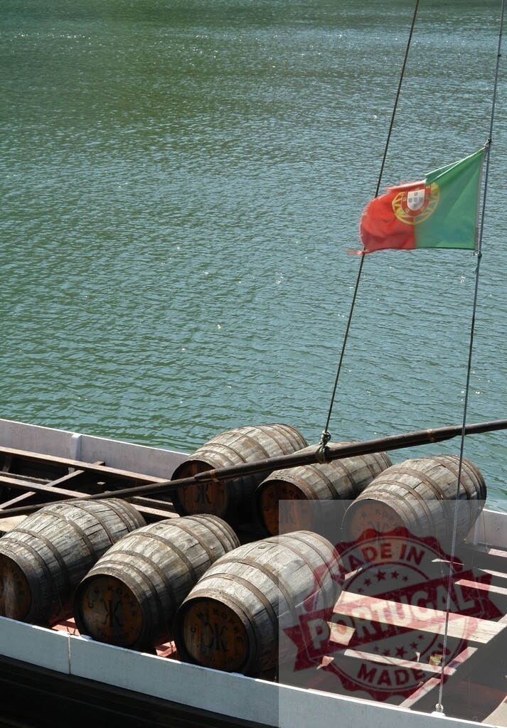 Douro river rabelo boat transporting port wine barrels. Porto - Portugal | Traditional rabelo boat carrying port wine barrels from Alto Douro on the Douro river - Realized with Pictrs.com
