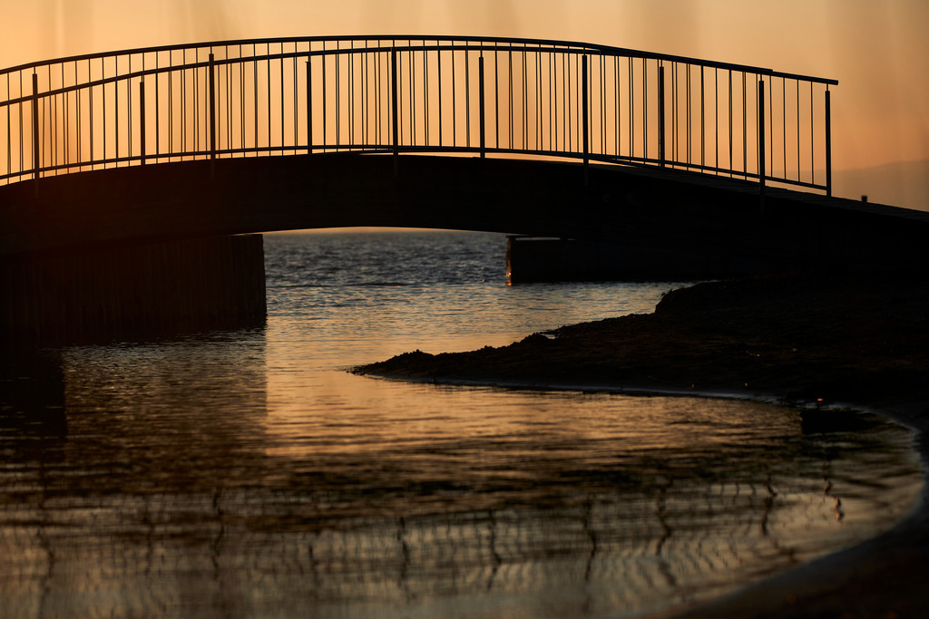 Fussgängerbrücke über den Bach am See | Weiden am See, Austria - March 01, 2021: Fussgängerbrücke über einen Bach am Neusiedlersee. - Realisiert mit Pictrs.com