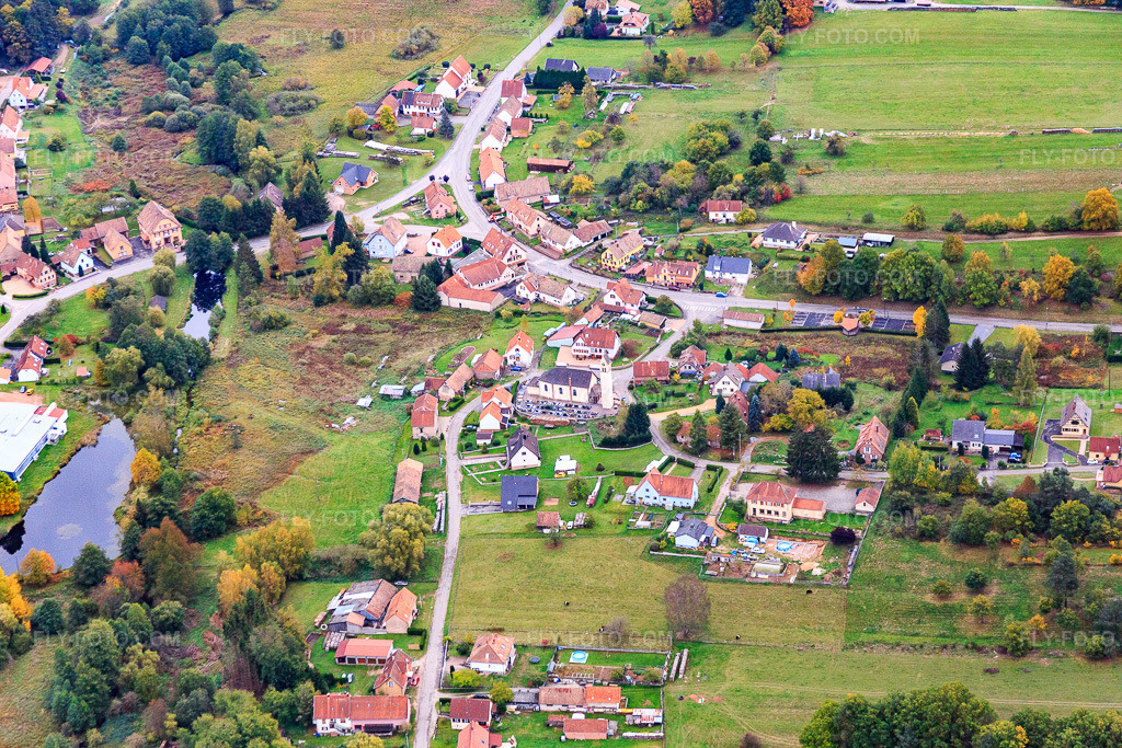 Aerial view: Village center with chapel at the Cimetière de Neunhoffen in Dambach in the state Bas-Rhin, France. – Photo: IMG_084666.jpg taken on 10/23/2015 by Werner Riehm/FLY-FOTO.com – Resolution of the original: 5472 x 3648 px – Affichage cimetière - Choix de la Ville