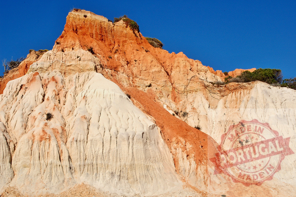 Algarve Praia da Falesia red eroding rock cliff | Eroding red and white limestone rock formation creating a textured landscape under a clear blue sky - Realized with Pictrs.com