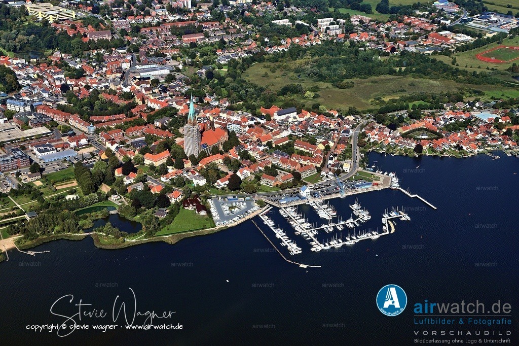 Luftbildfotografie in Schleswig: Ein unverzichtbares Erlebnis am Ostseefjord Schlei | Schleswiger Stadthafen: Die historische Hafenlage ist eng mit der Stadt Schleswig verbunden, direkt dahinter erhebt sich der Schleswiger Dom und in unmittelbarer Nähe befindet sich die idyllische Fischersiedlung Holm, was die kulturelle und historische Bedeutung des Hafens unterstreicht.