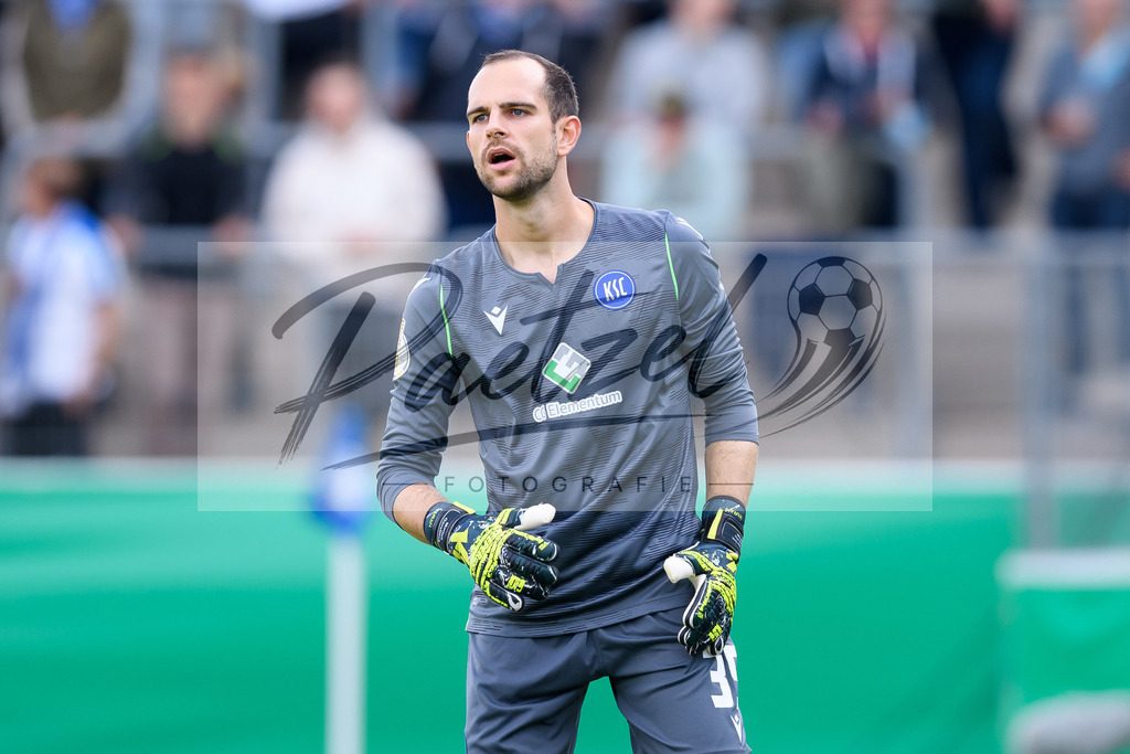 LOTKSC20210809_079 | Fussball, Herren: Torwart Marius Gersbeck (Karlsruher SC) schaut beim Spiel der 1. Runde im DFB-Pokal zwischen SF Lotte und Karlsruher SC im Stadion am Lotter Kreuz am 09.08.2021 in Lotte, Deutschland.DFB / DFL REGULATIONS PROHIBIT ANY USE OF PHOTOGRAPHS AS IMAGE SEQUENCES AND/OR QUASI-VIDEO. - Realisiert mit Pictrs.com