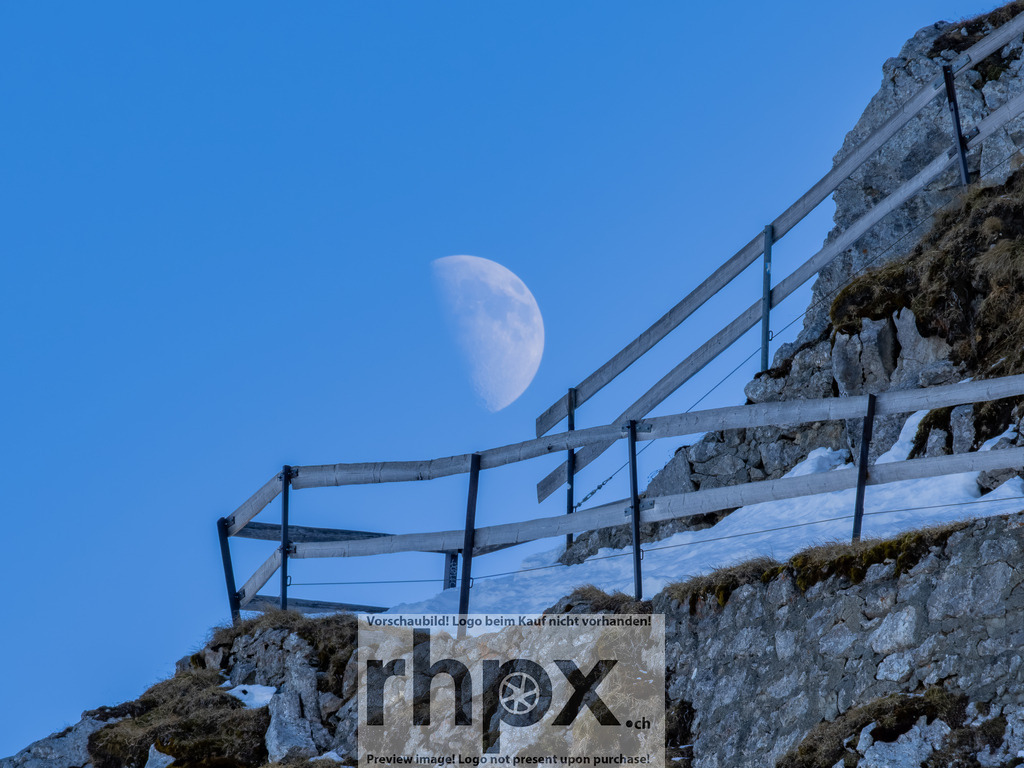 Mondaufgang am Pilatus Esel | <p><strong>Mond. Fels. Stille.</strong></p>
<p>Der blasse Tagesmond schiebt sich sanft hinter dem schroffen Grat des Esels hervor. Ein stilles Schauspiel am helllichten Tag, das die raue Schönheit der Innerschweizer Bergwelt auf minimalistische Weise unterstreicht.</p>
<p>Wähle unter "Produktauswahl" dein Wunschformat: Vom klassischen Wandbild über Puzzle & Tassen bis zum digitalen Download (z.B. als Handy-Hintergrund).</p>
<br> - Realisiert mit Pictrs.com