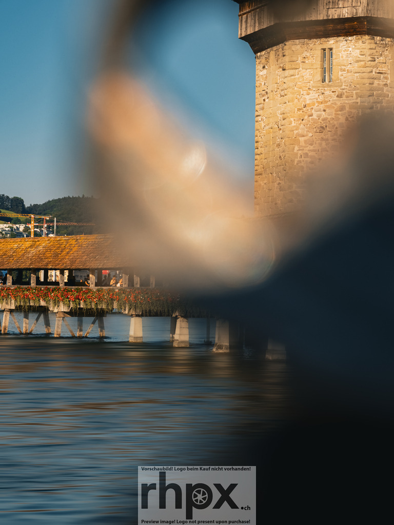Kapellbrücke Luzern Fokus | Geschichte. Rahmen. Klarheit.
Der Blick durch das schmiedeeiserne Ornament lenkt den Fokus direkt auf den historischen Wasserturm und die hölzerne Kapellbrücke. Die kräftigen Farben des Wassers und der Architektur fangen die zeitlose Atmosphäre der Stadt Luzern perfekt ein. Ein Spiel aus Form und Tradition.
Wähle unter "Produktauswahl" dein Wunschformat: Vom klassischen Wandbild über Puzzle &amp; Tassen bis zum digitalen Download (z.B. als Handy-Hintergrund). - Realisiert mit Pictrs.com
