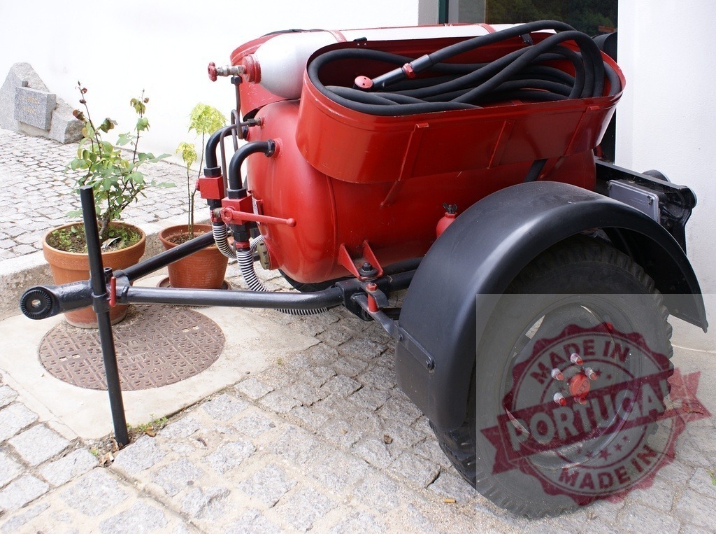 Vintage mobile firefighting pump with hose reel | Red vintage mobile firefighting pump with coiled hose on cobblestone pavement outdoors - Realized with Pictrs.com