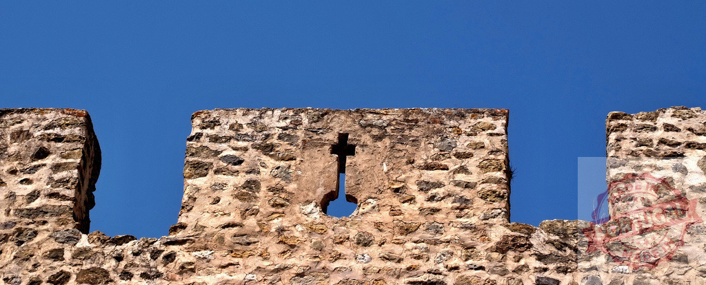 Stone medieval castle wall with arrowslit against sky | Stone wall with battlement and arrowslit protecting a historic fortress - Realisiert mit Pictrs.com
