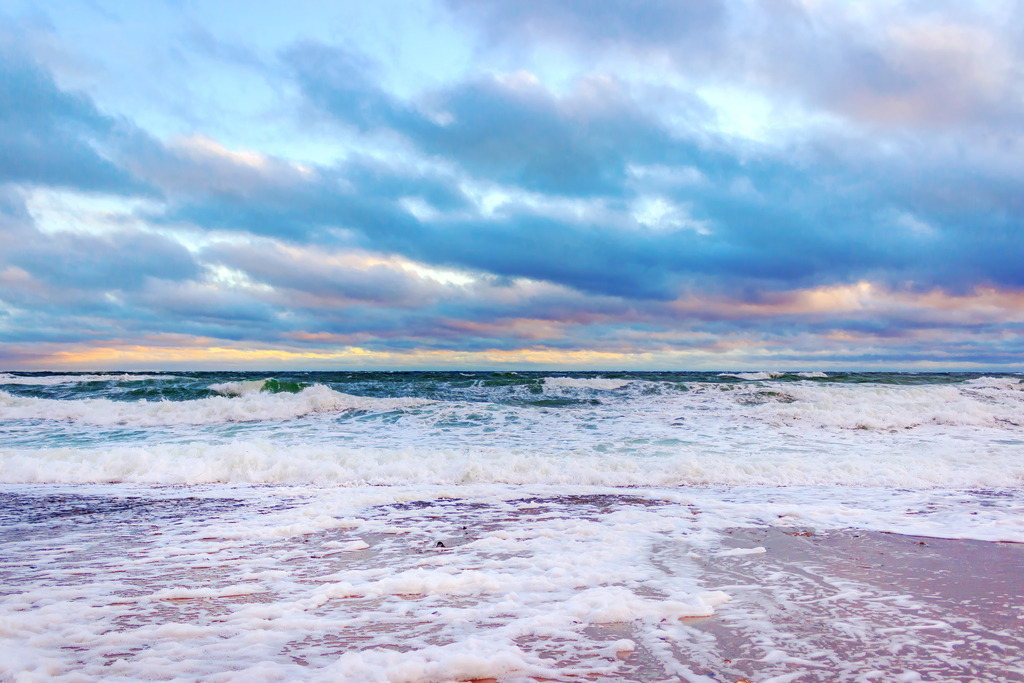 Wandbild: Küstenkraft – Wilde Brandung unter Wolken | Bringen Sie die ursprüngliche Energie und die frische Brise der Ostsee direkt in Ihr Wohnzimmer. Dieses maritime Wandbild fängt das kraftvolle Aufrollen der Wellen an einem windigen Tag ein. Die strahlend weiße Gischt im Vordergrund bildet einen brillanten Kontrast zu dem tiefen Blau der See und dem dramatischen Wolkenspiel am Himmel. Ein ausdrucksstarkes Naturmotiv, das Weite und Charakter an Ihre Wand bringt – ideal für eine moderne Inneneinrichtung, die Akzente setzen möchte. - Realisiert mit Pictrs.com