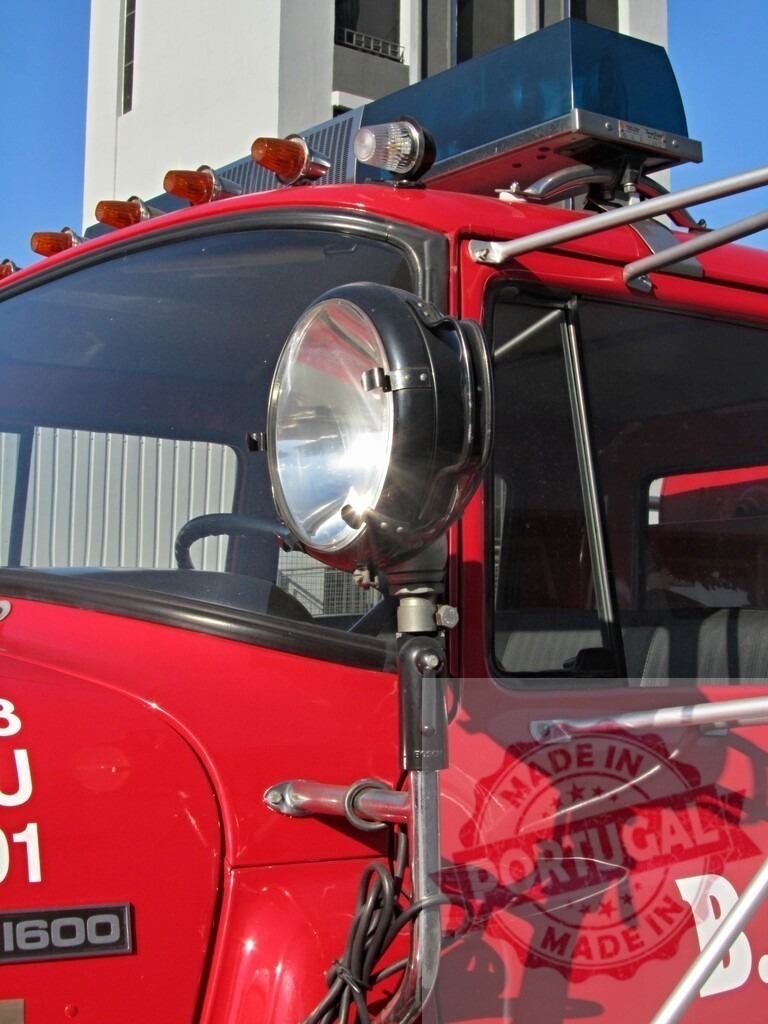 Red fire truck with spotlight and emergency lights | Red fire truck showing front detail with spotlight, lights, and cab - Realized with Pictrs.com
