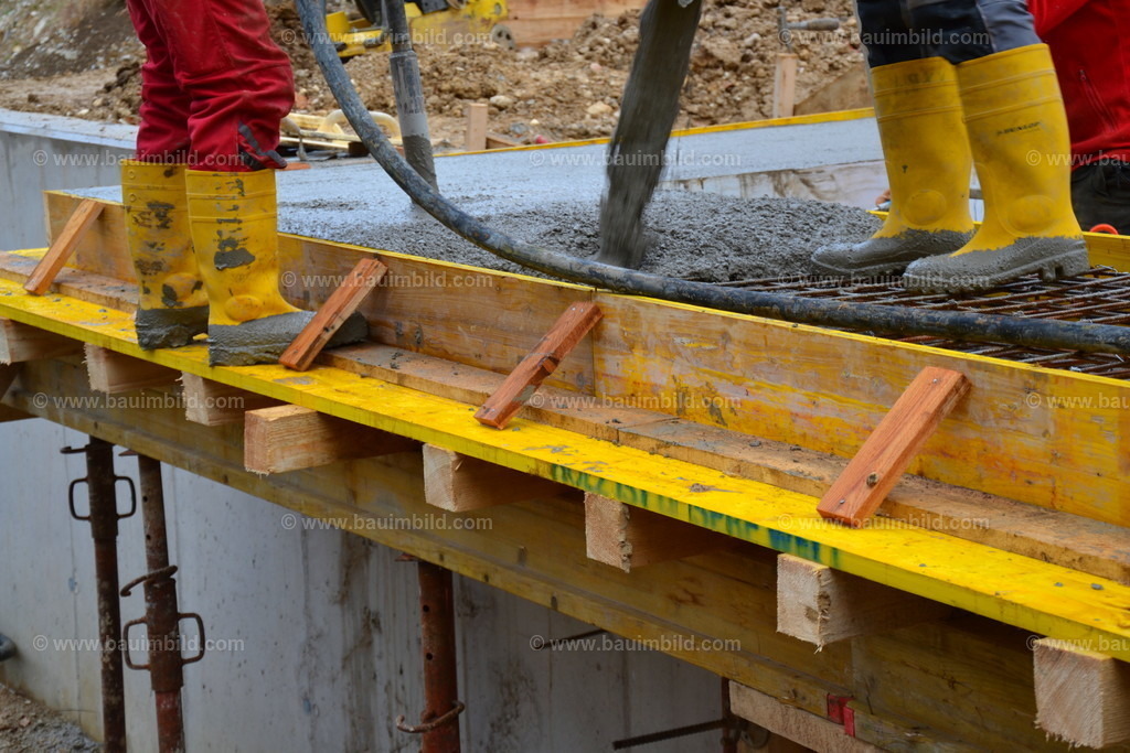 Betoneinbau Kragplatte | Arbeiter beim Betonieren und Verdichten von Beton mit Innenrüttler