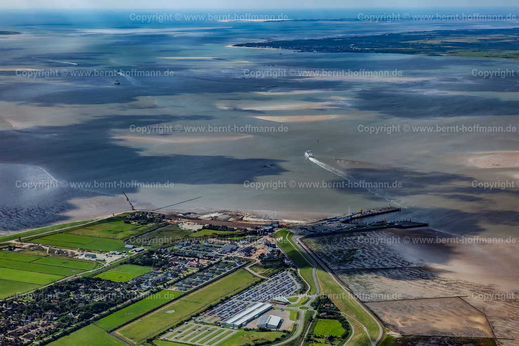 PLB_7231_Dagebuell_Watt_Inseln | LUFTBILD. Dagebüll mit Blick auf das Wattenmeer. __ Fährschiffe pendeln zwischen dem Festland und den vorgelagerten Inseln der Nordsee. Dunkle Wolkenschatten und helle Sandbänke gestalten die Meeres- Oberfläche abwechslungsreich. - Realisiert mit Pictrs.com