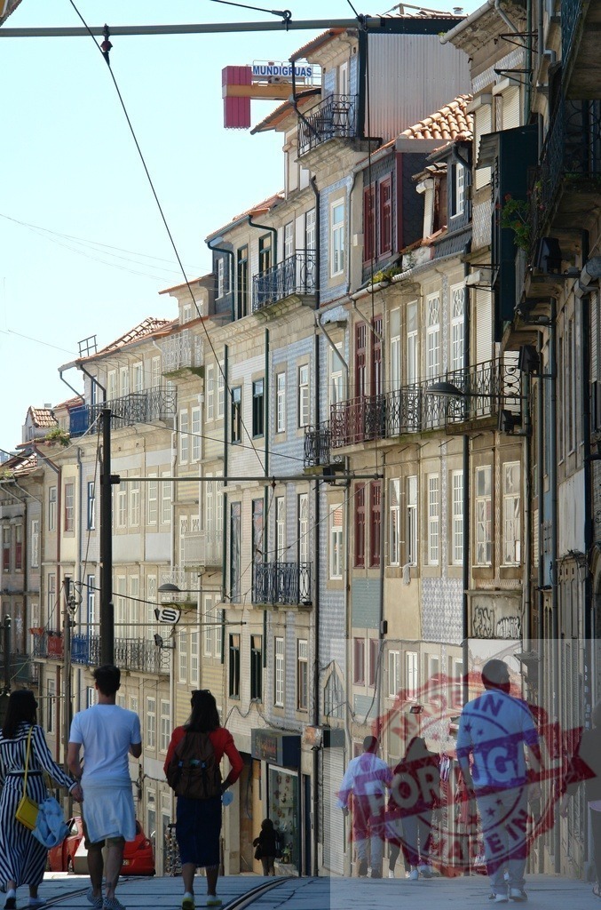 People walking uphill street in Porto, Portugal city | People walking up a steep urban street lined with traditional tiled buildings and balconies - Realisiert mit Pictrs.com