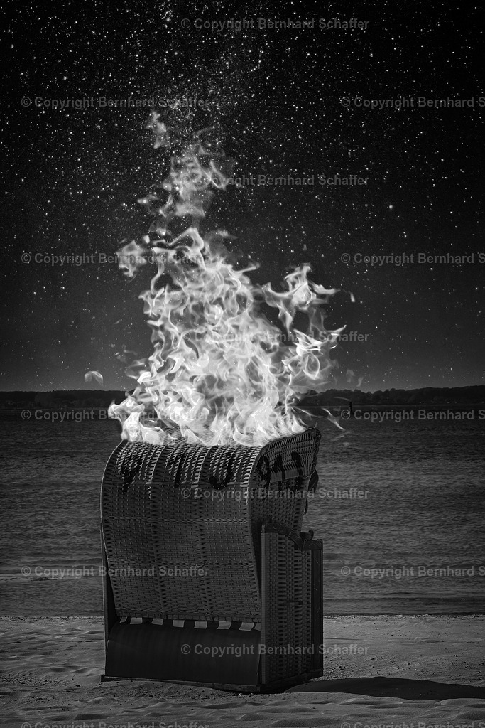 Strandkorb Feuer | Ein Strandkorb brennt an einem Strand an der Ostsee, schwarz-weiss. - Realisiert mit Pictrs.com