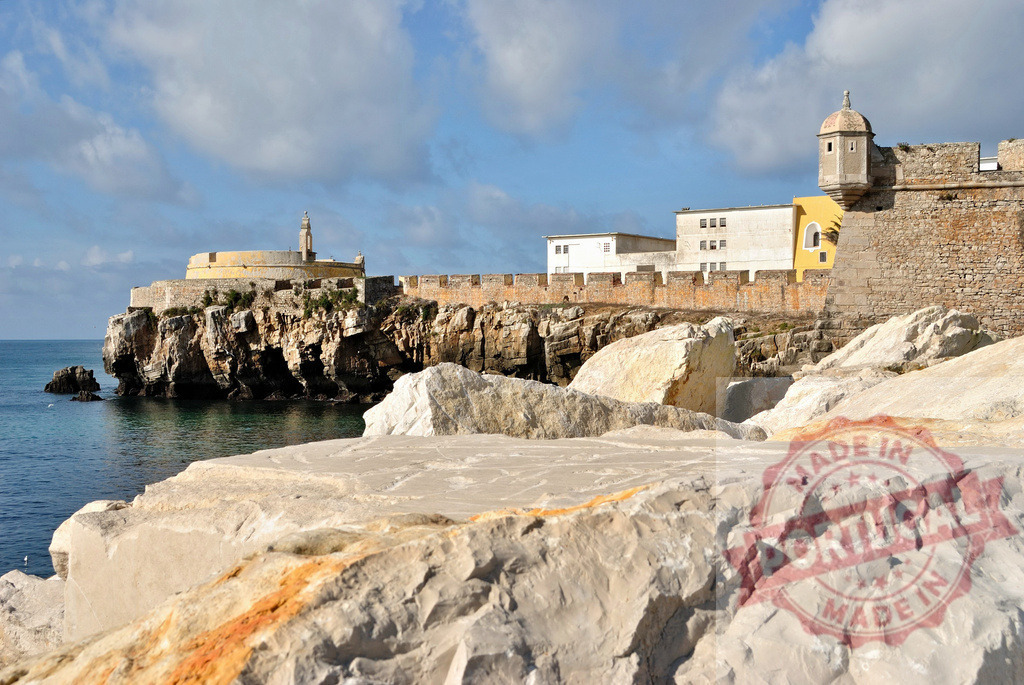 Fortress of Peniche protecting coastline in Portugal under blue sky. Centro - Portugal | Fortaleza de Peniche standing on a cliff by the Atlantic Ocean on a sunny day - Realized with Pictrs.com