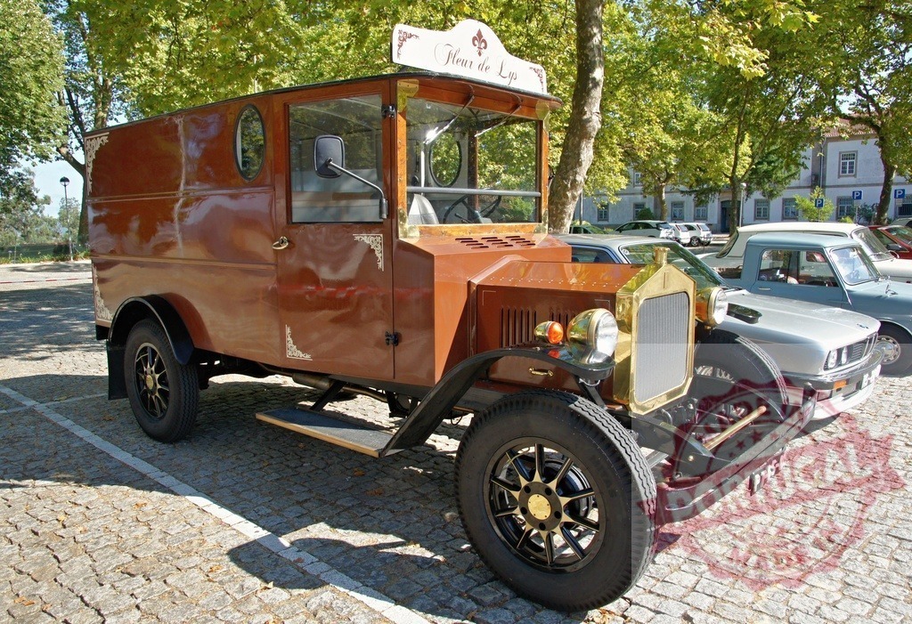 Restored antique delivery van Fleur de Lys parked in cobblestone square | Gleaming restored antique delivery van Fleur de Lys parked in a cobblestone square, showcasing its vintage charm and craftsmanship - Realized with Pictrs.com