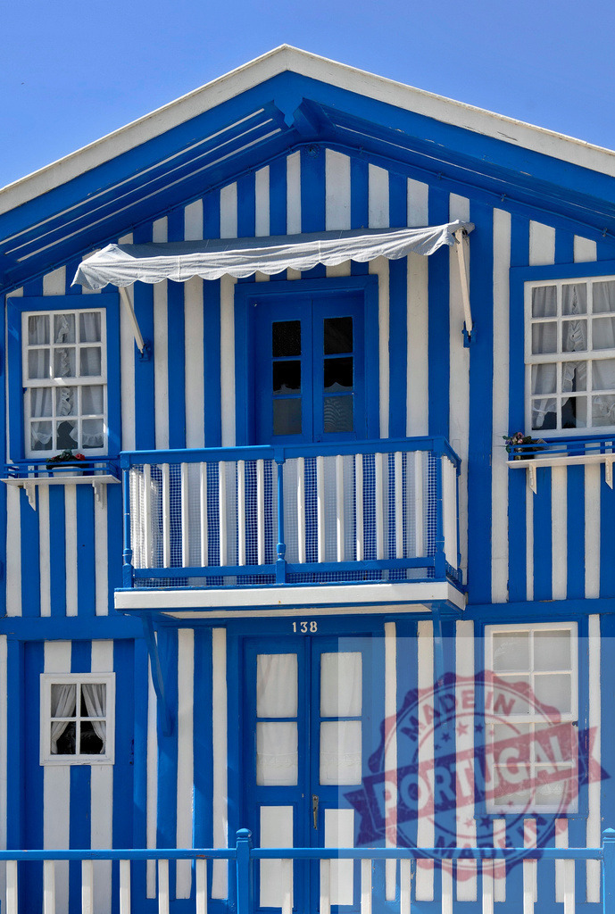 Costa Nova palheiro house featuring blue and white stripes | Traditional Portuguese wooden house with blue and white vertical stripes creating a distinctive facade - Realisiert mit Pictrs.com