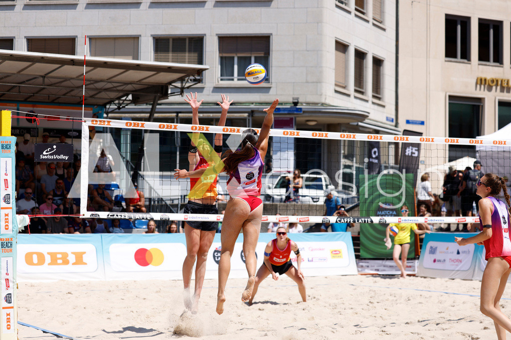 Obi BeachTour 2026 - Basel | BASEL, SWITZERLAND - JULY 18: ZOÉ FLÜCKIGER (SUI) attack / spike against LINDA ABBÜHL (SUI) block  during the Obi BeachTour 2026 match between BOSSART / ABBÜHL (SUI) and FLÜCKIGER / DEMIERRE (SUI) at Barfüsserplatz on July 18, 2026 in Basel, Switzerland. - Realisiert mit Pictrs.com
