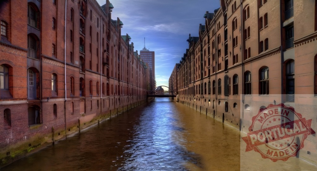 Hamburg Speicherstadt canal with historic brick warehouses | Historic brick warehouses line a reflective canal under a blue sky in Hamburg, Germany - Realisiert mit Pictrs.com