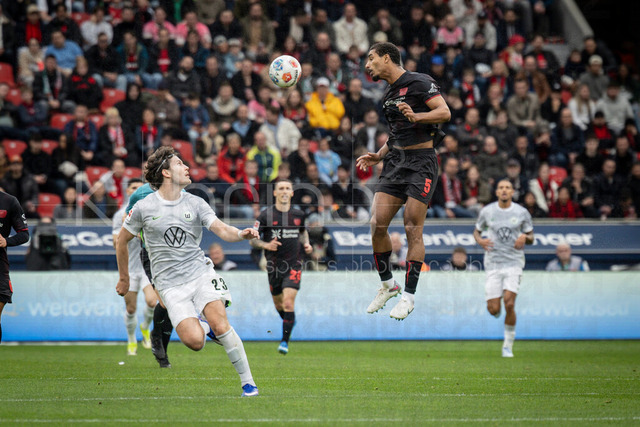 German Bundesliga, Bayer 04 Leverkusen vs. VfL Wolfsburg, 04.04.2026 | LEVERKUSEN, GERMANY - APRIL 4, 2026 :  Loic Bade (Bayer 04 Leverkusen, 5) he’s a ball, Jonas Wind (VfL Wolfsburg, 23) is looking at the scene during the German Bundesliga match on gameday 28 between Bayer 04 Leverkusen vs. VfL Wolfsburg at BayArena on April 4, 2026 in Leverkusen, Germany. DFL REGULATIONS PROHIBIT ANY USE OF PHOTOGRAPHS AS IMAGE SEQUENCES AND/OR QUASI-VIDEO.