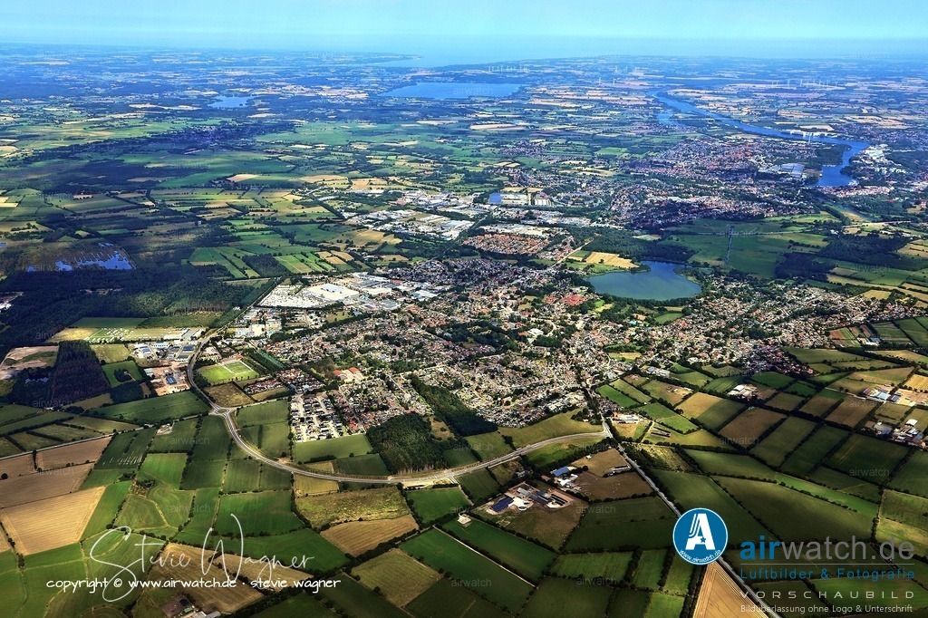 Luftbild Fockbek - Fockbek ist ein attraktiver Wohn- und Lebensort, der sowohl ländliche als auch städtische Vorteile vereint | Fockbek ist ein attraktiver Wohn- und Lebensort, der sowohl ländliche als auch städtische Vorteile vereint. Die Gemeinde ist familienfreundlich und verfügt über mehrere Kindergärten, eine Grund- und Gemeinschaftsschule (Bergschule Fockbek) sowie Tagesmütter für die Kinderbetreuung. Für die Nahversorgung gibt es mehrere Supermärkte und Fachgeschäfte, und für das Gesundheitswesen stehen mehrere Ärztinnen und Ärzte, Apotheken, ein Optiker und ein Akustiker zur Verfügung. Die Wirtschaft wird durch rund 450 Betriebe mit über 2.500 Arbeitsplätzen geprägt, darunter das Hobby-Wohnwagenwerk.