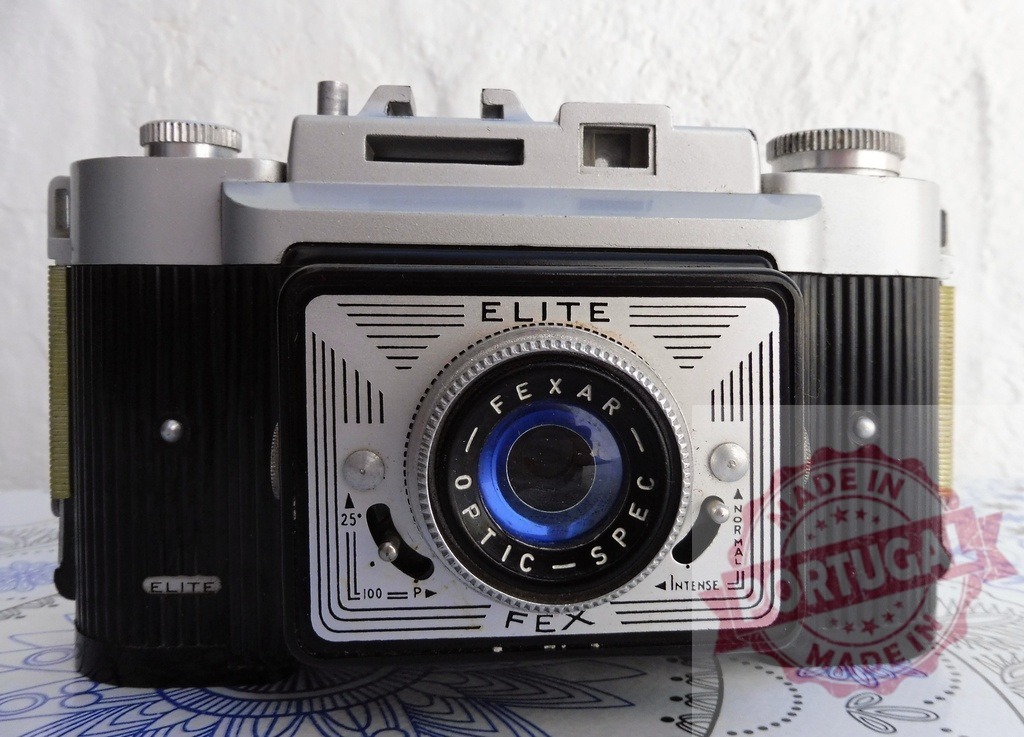 Fex Elite Fexar vintage film camera capturing retro style | Fex Elite Fexar vintage film camera sitting on a white and blue patterned surface - Realized with Pictrs.com