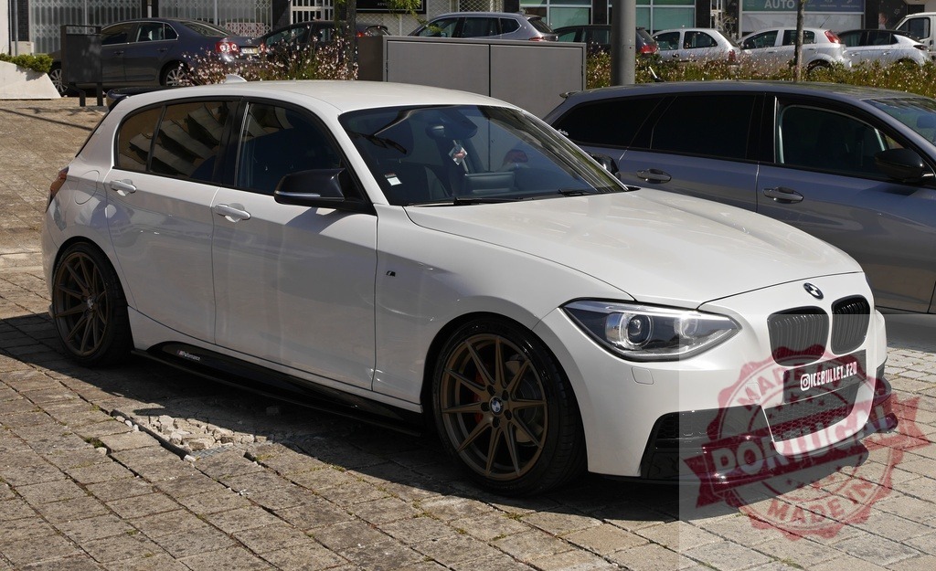 White customized BMW 1 Series hatchback parking | White BMW 1 Series hatchback with aftermarket wheels and body kit parked on a sunny day - Realized with Pictrs.com
