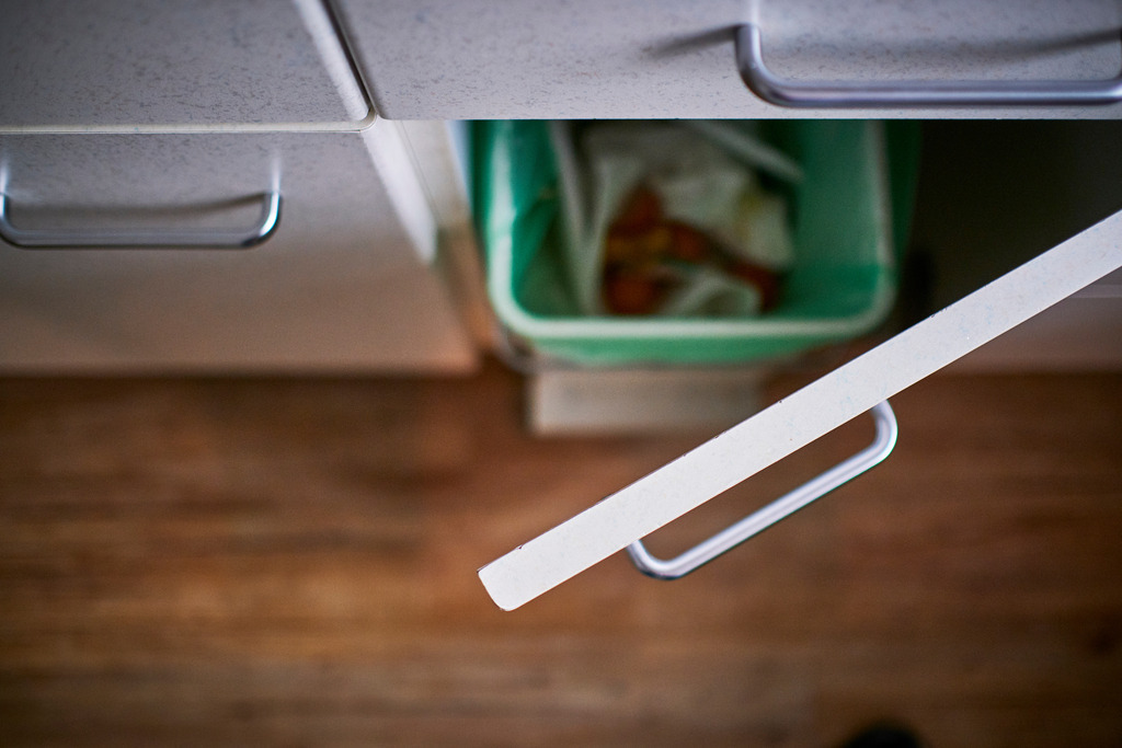 Küchenkasten mit Mülleimer | Wien, Austria - April 03, 2020: Putzen im Frühling, offenstehende Türe im Küchenkasten mit Blick in den Mülleimer. - Realisiert mit Pictrs.com