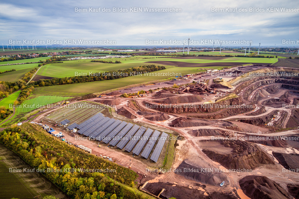 Mammendorf PV-Anlage Oktober2 Luftild-0024 | Die Drohnenaufnahme zeigt einen weiteren Bauabschnitt der Photovoltaikanlage im Andesit-Steinbruch. Das erste Solarmodul ist bereits auf der Unterkonstruktion aufgelegt, während die Montage der Anlage weiter voranschreitet. Im Hintergrund sind der Steinbruch mit seinen markanten Abbauflächen und die Fahrwege des Betriebsgeländes deutlich zu erkennen. Die Aufnahme dokumentiert anschaulich das Zusammenspiel von Solarprojekt und bestehender Steinbruchlandschaft.Die Aufnahme ist Teil des Mitteldeutschen Bildarchivs von Luftbildfotograf Steffen Lehmann. - Realisiert mit Pictrs.com