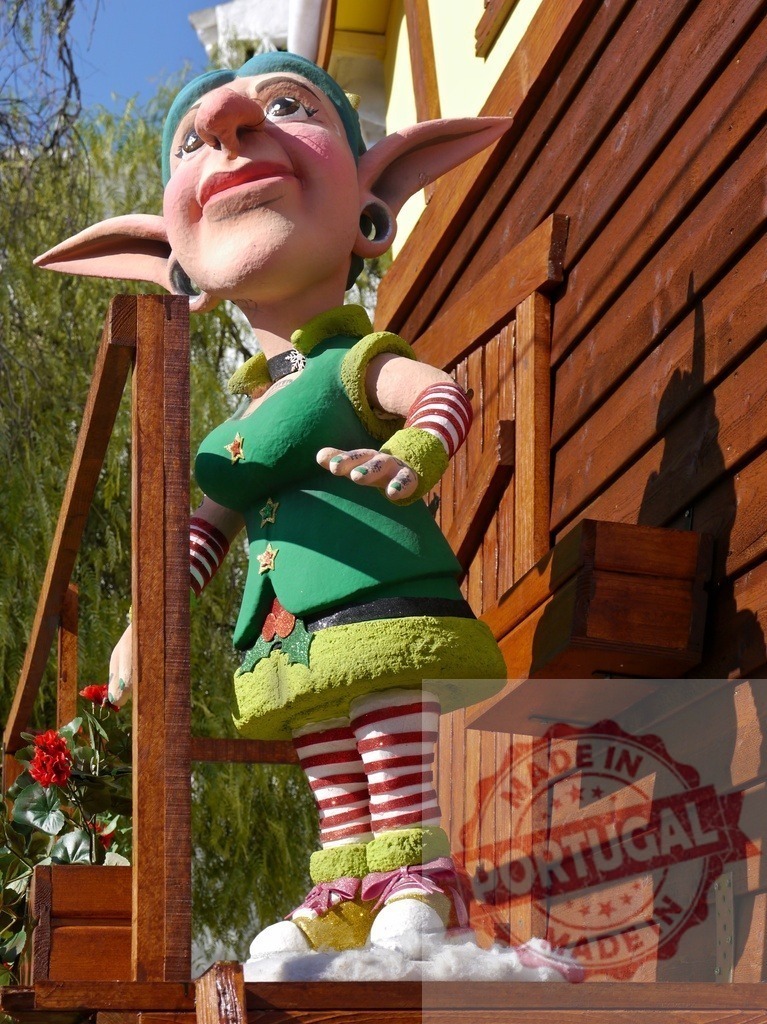 Christmas elf statue greeting from wooden house porch | Christmas elf statue standing on a wooden porch and greeting someone - Realized with Pictrs.com