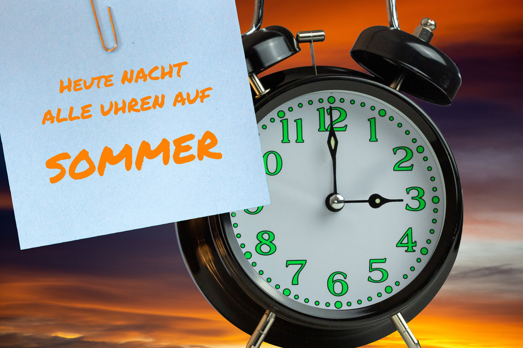 Zeitumstellung Sommerzeit 2026: Wecker und Notizzettel als Erinnerung zur Zeitumstellung | (Fotomontage) Zeitumstellung Sommerzeit Symbolbild: Wecker vor abendlichem Himmel und Text HEUTE NACHT ALLE UHREN AUF SOMMER - Realisiert mit Pictrs.com