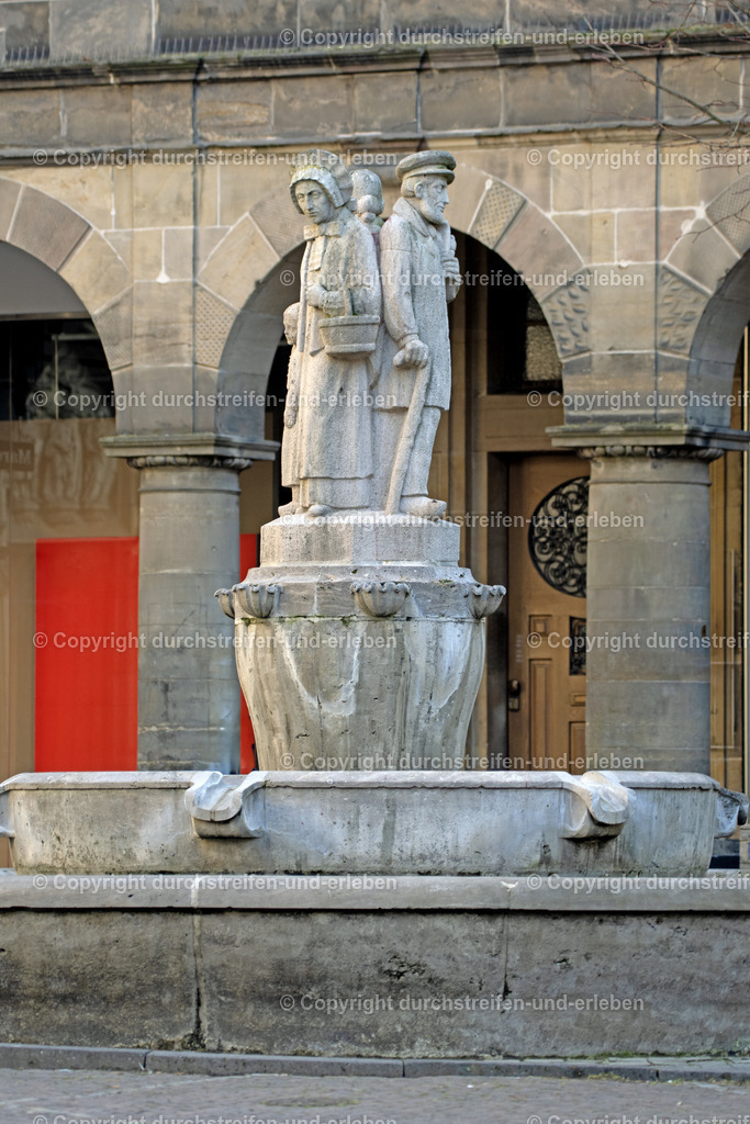 Lambertibrunnen vom Prinzipalmarkt  aus | Der Lambertibrunnen in Münster weist auf eine bäuerliche Familie beim Tanzen zu Ehren des Heiligen Lambertus hin. - Realisiert mit Pictrs.com