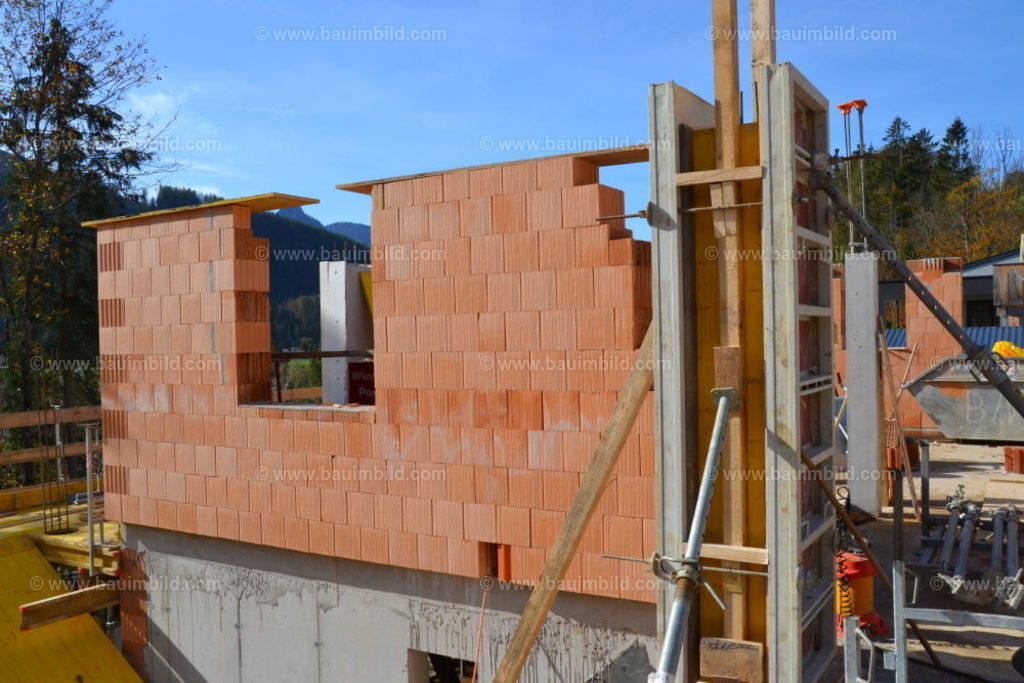 Außenwand Ziegelhaus | Außenmauerwerk mit Abdeckung und eingeschalter Stütze, Hintergrund blauer Himmel