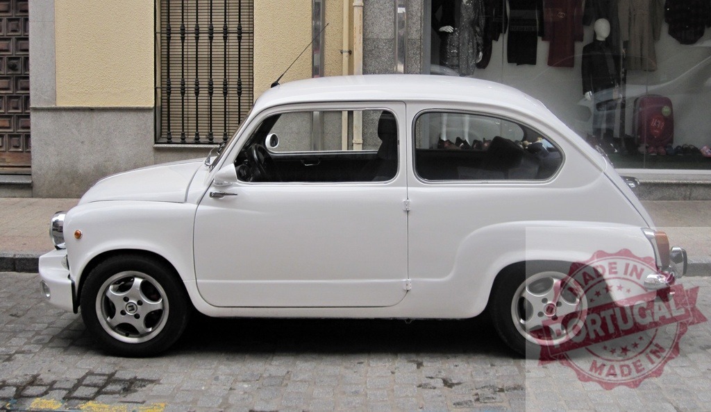 White Seat 600 parked on the street next to a fashion shop window | Classic white Seat 600 parked on a cobblestone street in an urban setting - Realized with Pictrs.com