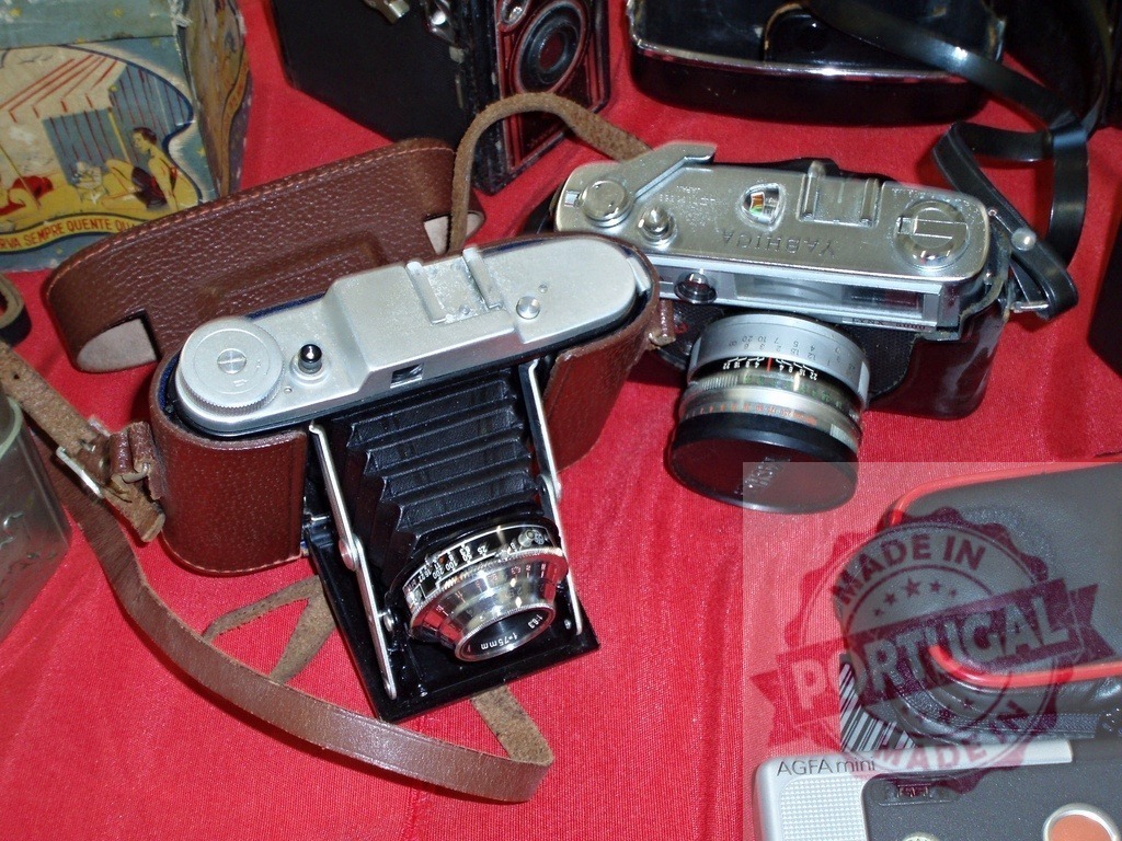 Vintage film cameras displayed for a retro collection | Collection of old film cameras including a folding camera and Yashica rangefinder - Realized with Pictrs.com