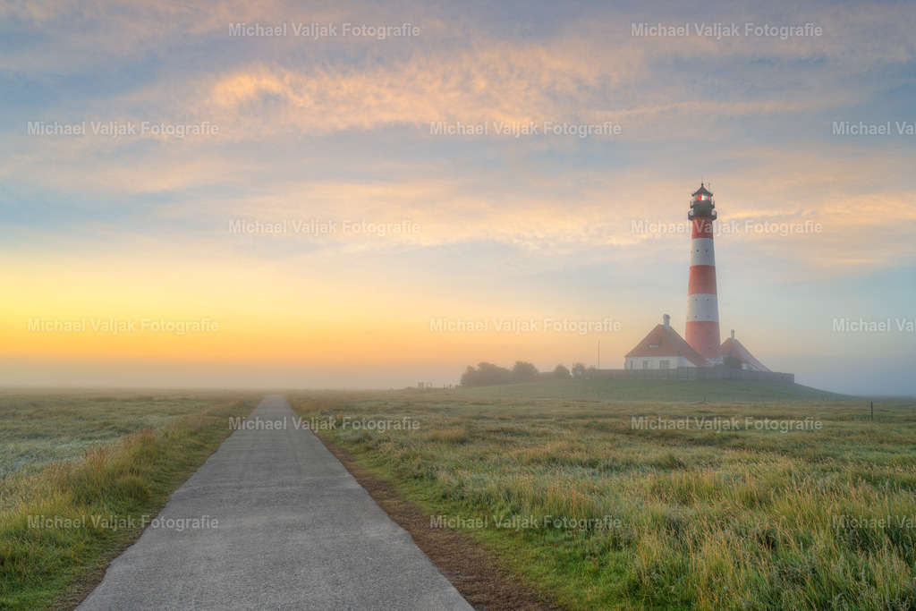 Leuchtturm Westerheversand im Morgennebel | Nebeliger Morgen beim Leuchtturm Westerheversand auf der Halbinsel Eiderstedt in Nordfriesland. Langsam lichtet sich der Nebel und gibt den Blick auf den Leuchtturm und den Sonnenaufgang frei.  - Realized with Pictrs.com