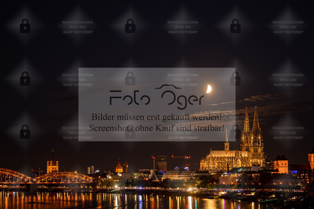 Kölner Dom bei Nacht – Mond über dem Rhein | Ein nächtlicher Blick auf den Kölner Dom, majestätisch erleuchtet unter einem halbverhüllten Mond.Die goldenen Lichter der Stadt spiegeln sich im Rhein und verleihen der Szene eine fast magische Ruhe.Dieses stimmungsvolle Nachtbild vereint architektonische Pracht mit der stillen Schönheit des Himmels – ein Sinnbild für die Magie urbaner Nächte. - Realisiert mit Pictrs.com