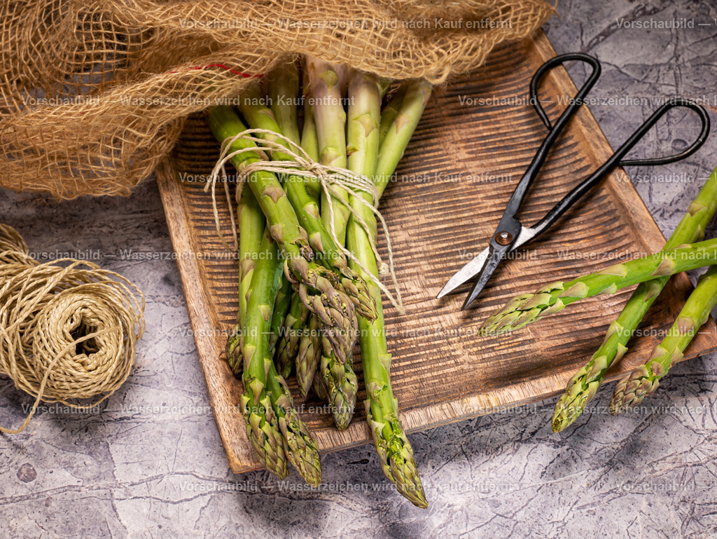 ein Bund frischer, grüner Spargel in rustikaler Holzschale | ein Bund frischer, grüner Spargel in rustikaler Holzschale mit Garn und vntage Schere - Realisiert mit Pictrs.com