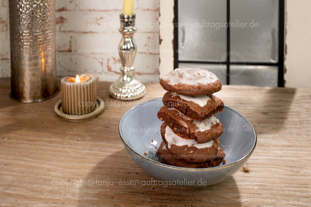 Plätzchen aus Lebkuchenteig stehen gestapelt in einer Schale  vor einem vereisten Fenster.  | Plätzchen aus Lebkuchenteig stehen gestapelt in einer Schale  vor einem vereisten Fenster. 
