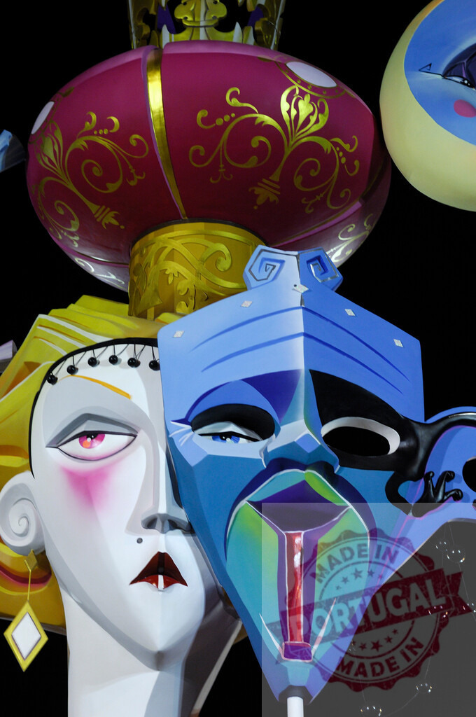 Fallas festival ninot sculpture with colorful mask and caricature | Fallas ninot sculpture displaying a colorful mask on a caricature face against a dark background - Realized with Pictrs.com