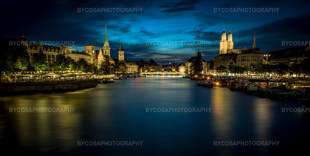 Blue Hour Over Zürich _ Limmat Nightscape | Ein atemberaubendes Langzeitbelichtungspanorama von Zürich, aufgenommen in der magischen blauen Stunde. Sanfte Spiegelungen auf der Limmat, warmes Stadtlicht und das ikonische Trio – Fraumünster, St. Peter und Grossmünster – schaffen eine perfekte Harmonie zwischen Farben, Architektur und nächtlicher Atmosphäre.Dieser elegante und moderne FineArt-Druck verleiht jedem Raum Ruhe, Tiefe und Luxus. - Realisiert mit Pictrs.com