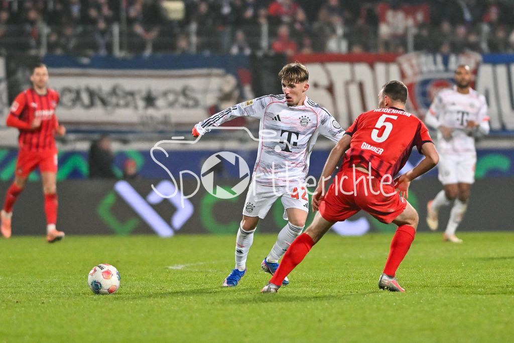 1. FC Heidenheim - FC Bayern München | HEIDENHEIM, GERMANY - 21. DECEMBER: im Duell Lennart KARL (FC Bayern Munich 42) und Benedikt GIMBER (1. FC Heidenheim 5) während dem Bundesligamatch zwischen dem 1. FC Heidenheim und dem FC Bayern München am 15. Spieltag in der Voith-Arena / DFL REGULATIONS PROHIBIT ANY USE OF PHOTOGRAPHS AS IMAGE SEQUENCES AND/OR QUASI-VIDEO