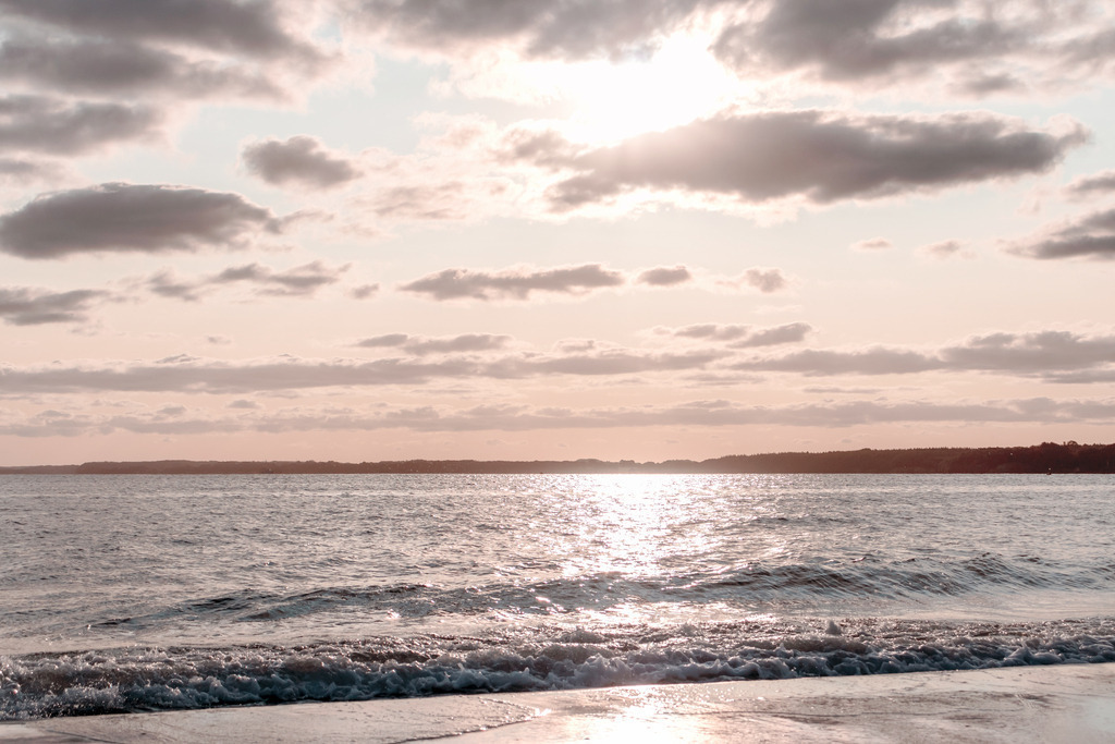Wandbild: Sonnenaufgang am Meer | Dieses Wandbild zeigt die aufgehende Sonne am Meer. Die Sonne spiegelt sich auf der Wasseroberfläche. Am orangeroten Himmel befinden sich graue Wolken, die teilweise vom Morgenrot angeleuchtet werden. Kaufen Sie sich diese schöne maritime Morgenstimmung auf Leinwand, Aluminium-Platte oder Acrylglas. Ideal fürs Wohnzimmer, Schlafzimmer, Küche, den Arbeitsplatz oder die Ferienwohnung. Die Wandbilder werden individuell für Sie in vielen Abmessungen produziert. Daher passen die Ostseekult Wandbilder immer perfekt an Ihre Wände. - Realisiert mit Pictrs.com